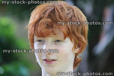 Stock image of boy, boy's face smiling, daydreaming / looking, red hair