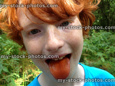 Stock image of red headed boy making a silly face, sticking out tongue