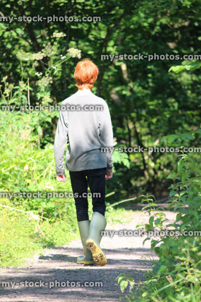 Stock image of teenage boy walking along pathway, footpath, wood / woodland / forest, red hair