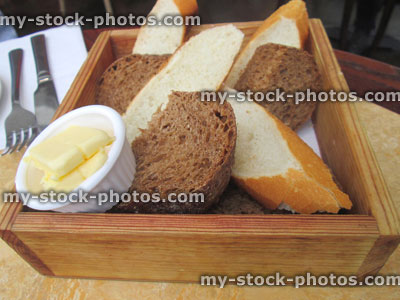 Stock image of freshly baked homemade slices bread in basket / box with butter