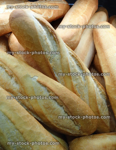Stock image of bread sticks and baguettes piled high in bakery