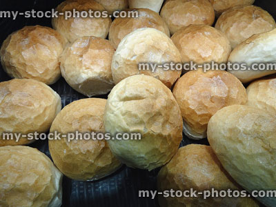 Stock image of freshly-baked white crusty bread rolls sold at bakery