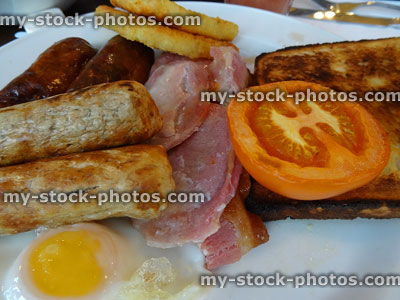 Stock image of fried breakfast with bacon, sausages, tomato, fried egg, toast