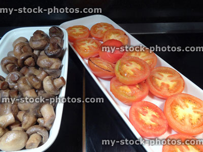 Stock image of full English fried breakfast buffet, grilled tomatoes, fried mushrooms, serving tongs