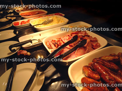 Stock image of self service fried breakfast buffet, sausages, bacon, eggs, baked beans
