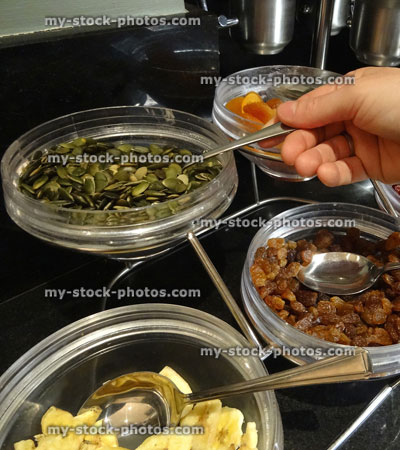 Stock image of glass bowls, nuts and dried fruit, pumpkin seeds, sultanas, dried apricots, dried bananas