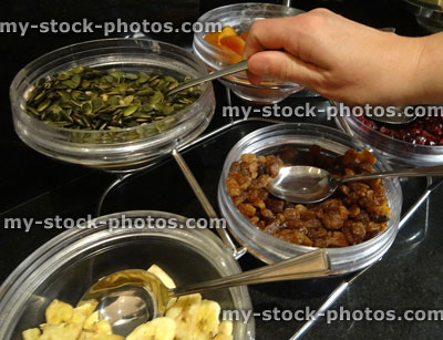 Stock image of glass bowls, nuts and dried fruit, pumpkin seeds, sultanas, dried apricots, dried bananas
