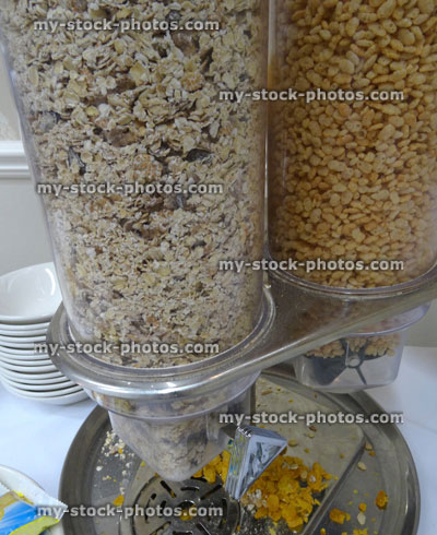 Stock image of glass breakfast cereal dispenser, muesli, porridge oats, crisped rice, cornflakes, breakfast buffet