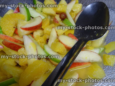 Stock image of large bowl of fresh fruit salad, serving spoon, healthy breakfast alternative