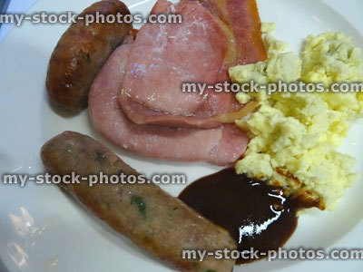 Stock image of full English fried breakfast, sausages, bacon, scambled egg, brown sauce