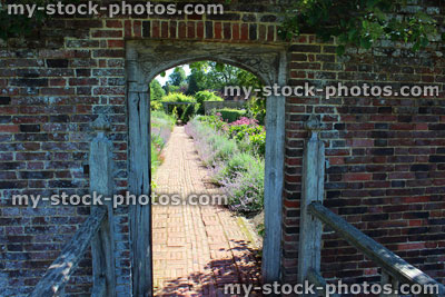 Stock image of stone wall arch leading to kitchen garden, ornamental vegetable garden