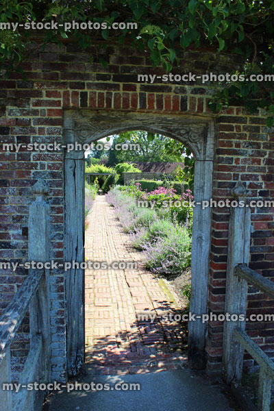 Stock image of stone wall arch leading to kitchen garden, ornamental vegetable garden