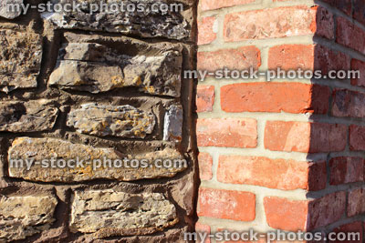 Stock image of formal red brick gate post, contrasting old cobblestone wall