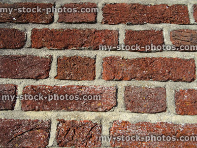 Stock image of dirty red brick wall, with mortar cement pointing