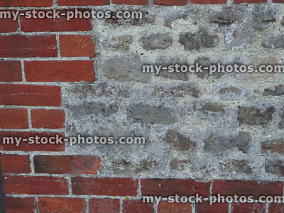 Stock image of red brick wall, hole filled with grey stone