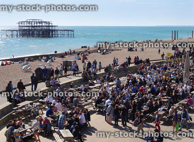 Stock image of crowds eating outside by old pier at Brighton beach