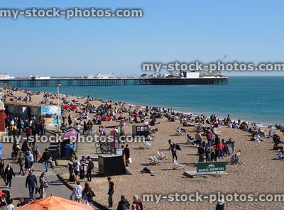 Stock image of Brighton pier and beach with summer holidaymaker crowds