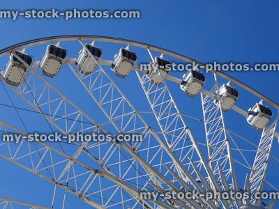 Stock image of a big wheel attraction pictured against blue sky