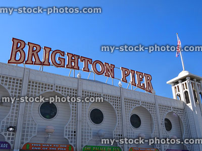 Stock image of Brighton Pier signpost with ornate trellis work and Union Jack flag