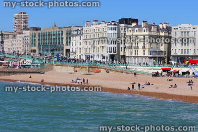 Stock image of families on sunny Brighton beach promenade, blue sea