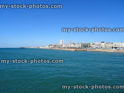 Stock image of Brighton coastline showing beach hotels, old pier, blue-sea
