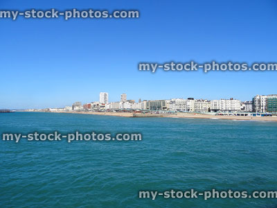 Stock image of Brighton beach with blue sky, sea, sand, coastal-buildings