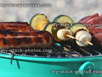 Stock image of sausages and kebabs cooking on charcoal barbecue grill