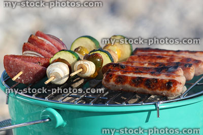 Stock image of sausages, chorizo / vegetable kebabs, cooking on beach barbecue