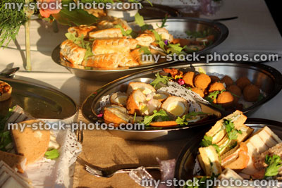 Stock image of buffet table of party food, sausage rolls, sandwiches
