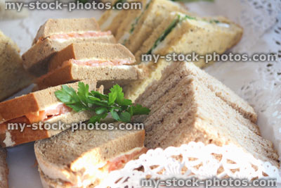 Stock image of triangular granary bread sandwiches, egg / lettuce, smoked salmon, ham, party food buffet