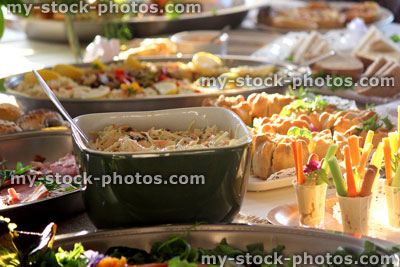 Stock image of people serving themselves, buffet table, party food, finger food