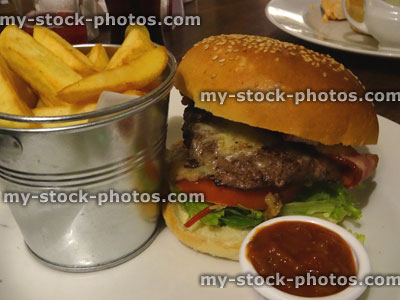 Stock image of gourmet burger, chunky chips in bucket, tomato ketchup