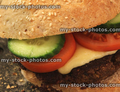 Stock image of homemade cheese burger with tomato, cucumber, sesame seed bun