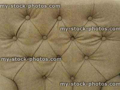 Stock image of beige, padded, button studded, fabric bed headboard background