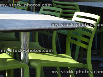 Stock image of alfresco cafe marble tables with green plastic chairs