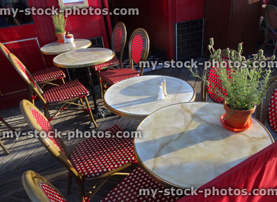 Stock image of round marble bistro tables and rattan chairs, French restaurant