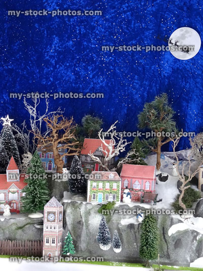 Stock image of cut out card houses in Christmas village, trees, blue sky