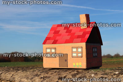 Stock image of cardboard dolls house, with field, tree and sky