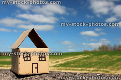 Stock image of cardboard dolls house, with field, trees and sky