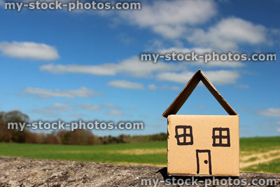 Stock image of cardboard dolls house, with field, trees and sky