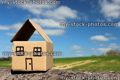 Stock image of cardboard dolls house, with field and blue sky 