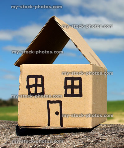 Stock image of brown cardboard box house / homemade dollshouse against blue sky