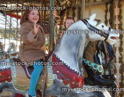 Stock image of children on fairground carousel horses