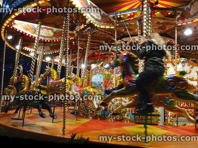 Stock image of funfair carousel roundabout with painted horses and light bulbs