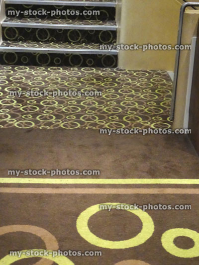 Stock image of hard wearing, short cut pile brown / yellow carpet, pattern of stripes and circles, stairs