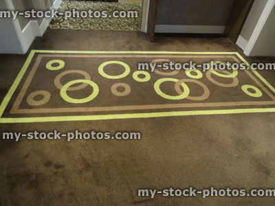 Stock image of hard wearing, short cut pile brown / yellow carpet with pattern of stripes and circles