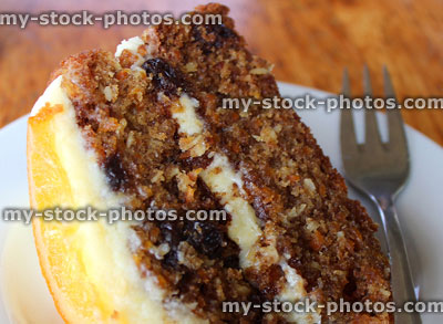Stock image of slice of homemade carrot cake, butter icing, candied orange