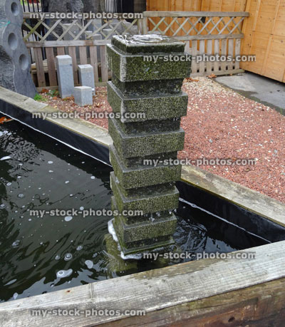 Stock image of square granite stone fountain, carved straight lines, garden water feature