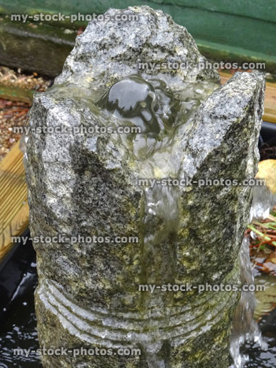 Stock image of round granite stone fountain, carved straight lines, garden water feature