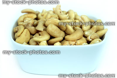 Stock image of cashew nuts, white dish of cashews, healthy snacks, diet food
